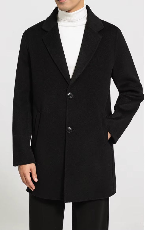 Men’s mid-length wool coat in Onyx, model’s hand in pocket. From Borcelleclothes.