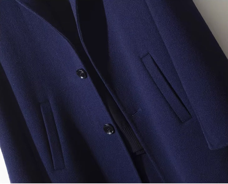 Middle section of men’s mid-length wool coat in Paua with side single-welt pockets. From Borcelleclothes.