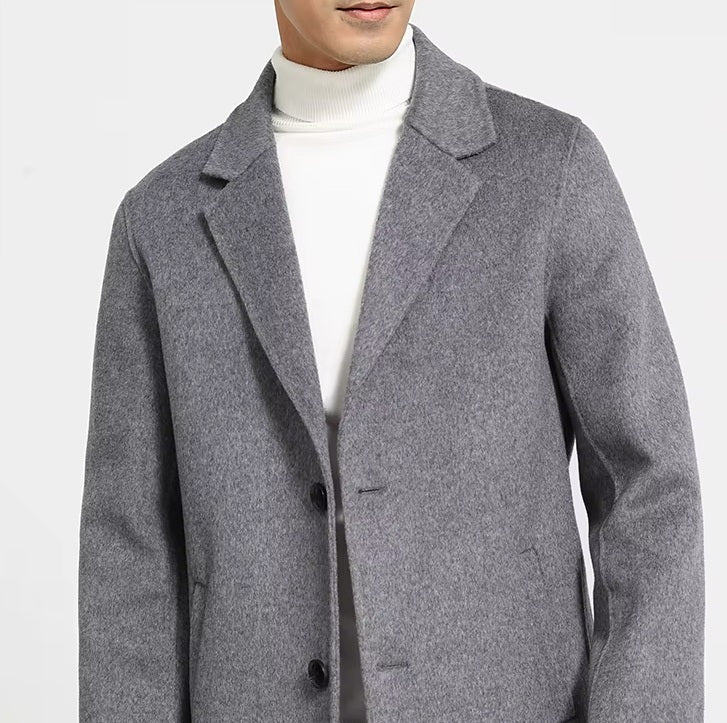 Upper part of men’s mid-length wool coat in Topaz, showing notch lapels and structured shoulders. From Borcelleclothes.