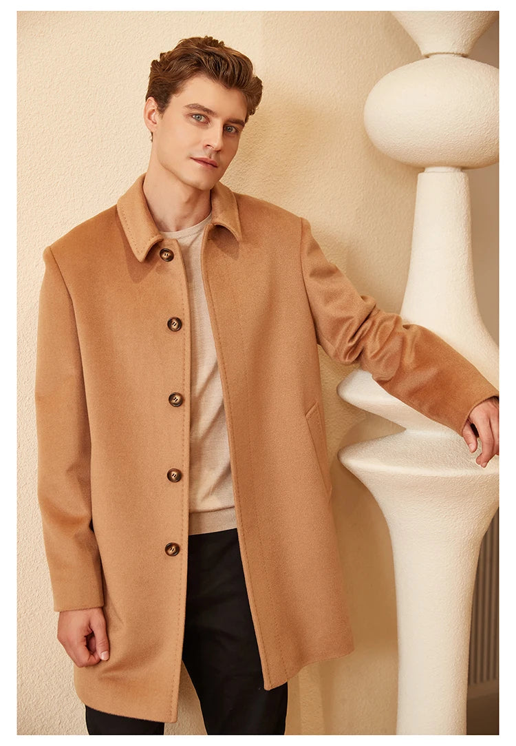 Model wearing the Men’s Minimalist Cashmere Coat in Burning Sand, standing near a decorative column, emphasizing the coat’s refined structure and warm-toned elegance. From Borcelleclothes.
