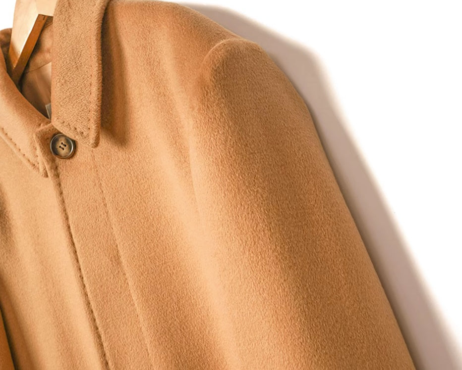 The Men’s Minimalist Cashmere Coat in Burning Sand, focusing on the structured shoulder construction and tailored sleeve attachment. From Borcelleclothes.