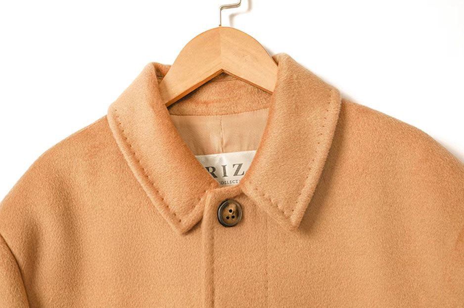 The upper part of the Men’s Minimalist Cashmere Coat in Burning Sand, emphasizing the notch lapels and structured shoulders. From Borcelleclothes.