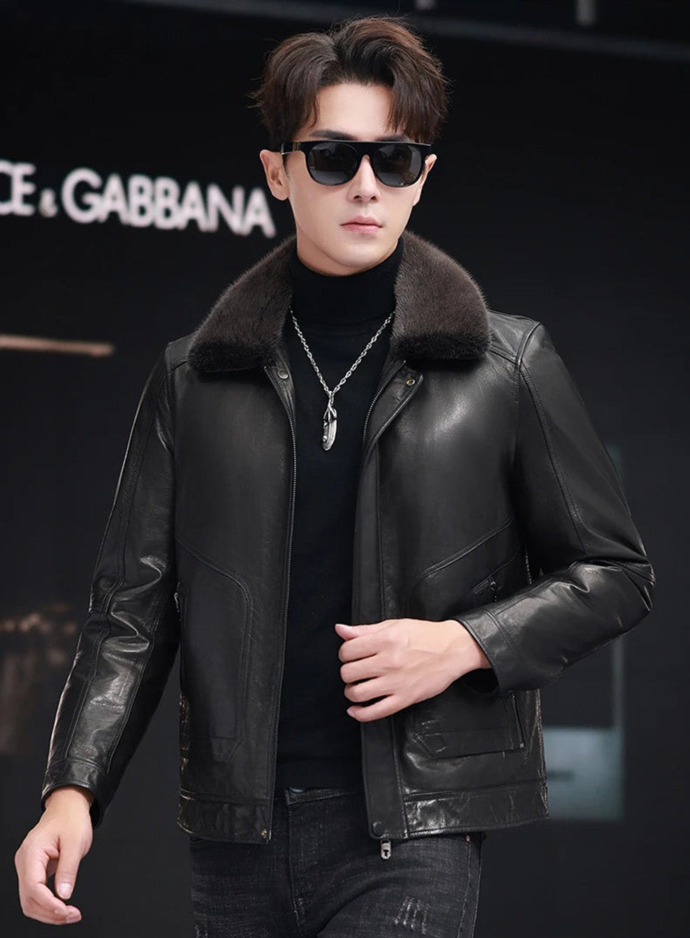 Man unzipping goatskin jacket with mink collar, hand at front edge — From Borcelleclothes.