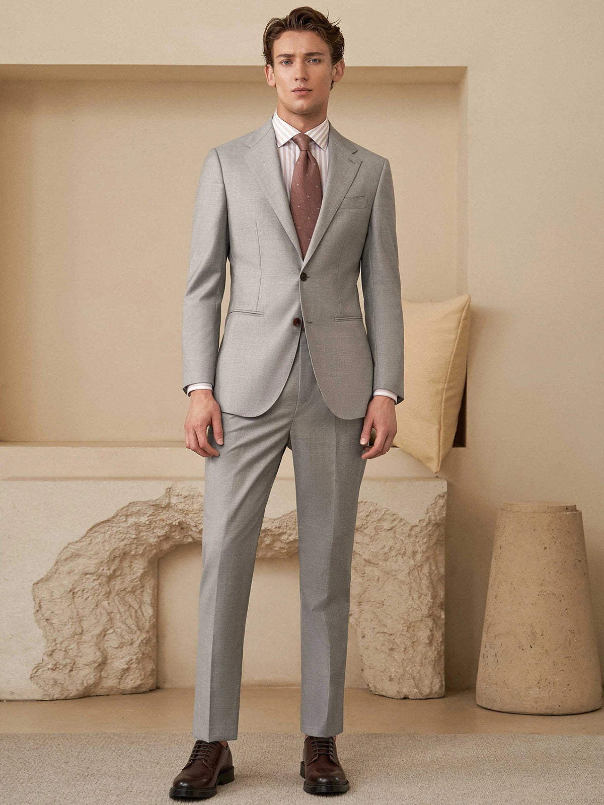 Model standing with arms straight, revealing the suit’s natural drape and balanced construction. From Borcelleclothes.