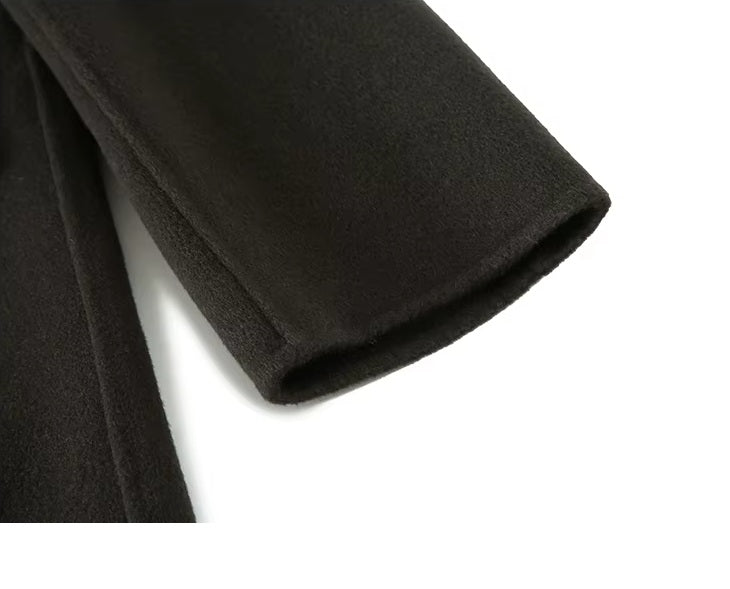 The sleeve end on the Men's Peaked-Lapel Wool Coat in Tuatara, highlighting the hand-stitched finishing and structured design. From Borcelleclothes.