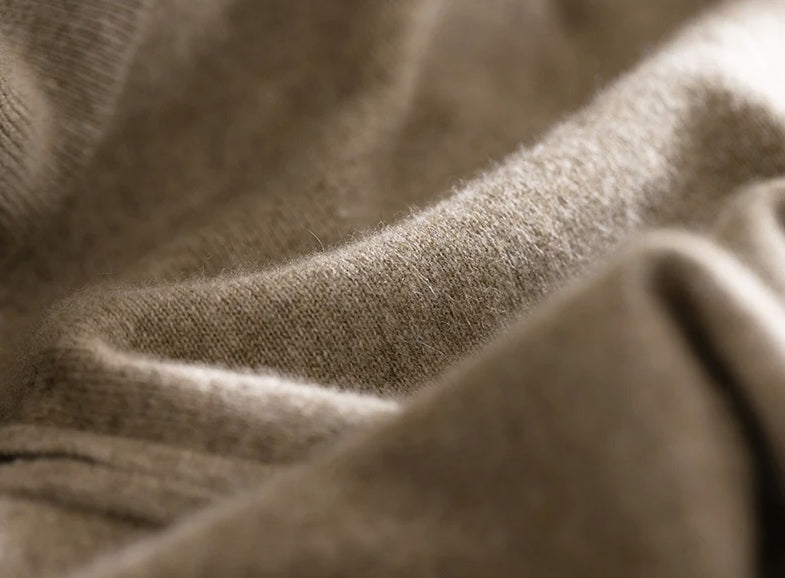Wave-folded demonstration of the plain stitch texture in Sandrift cashmere, showing the natural drape and softness of the knit — From Borcelleclothes.