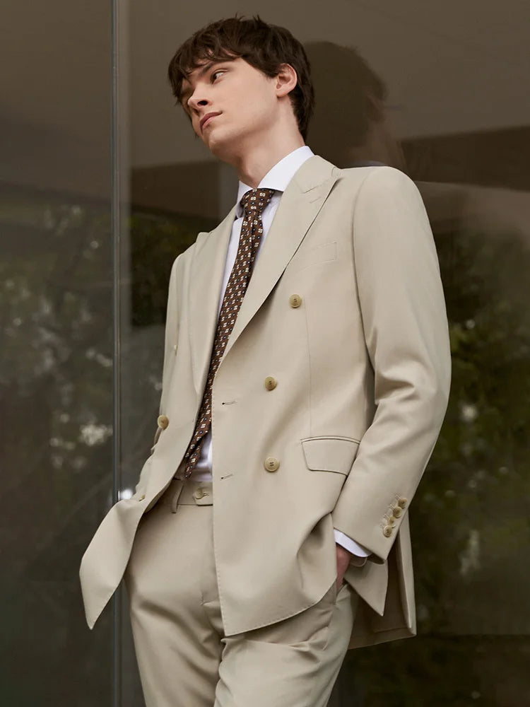 Model in Soft Amber double-breasted suit standing with both hands in the pants pockets, expressing aristocratic ease. From Borcelleclothes.