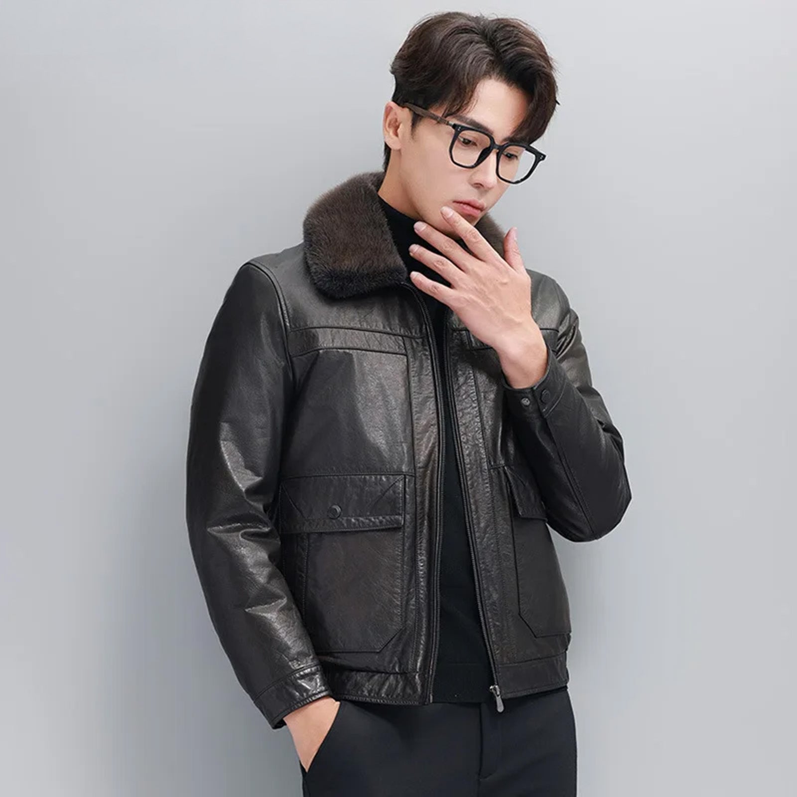 Model in the Wenge leather down jacket, touching chin and showing pointed mink collar — From Borcelleclothes.