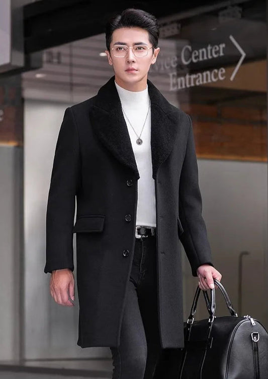Men’s wool-cashmere coat with shearling peaked lapels in Onyx, model holding a black leather duffle bag. From Borcelleclothes.