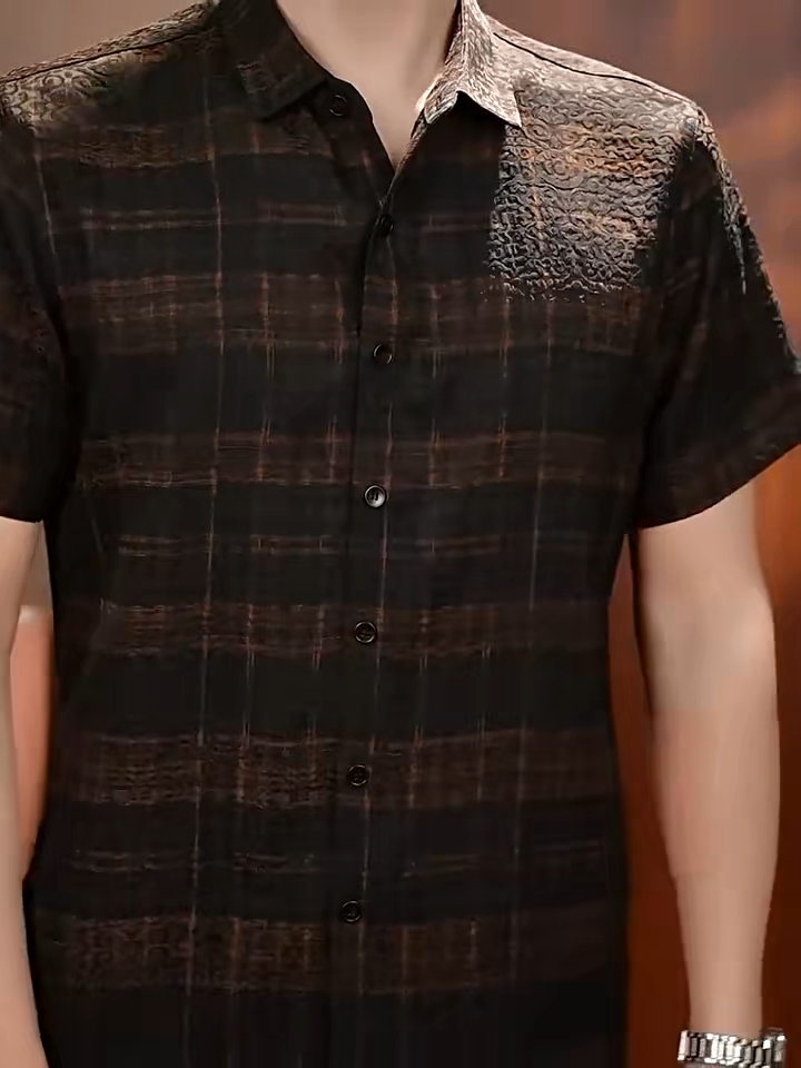 Video showcasing a Men's short-sleeve shirt in Baroque Graphite Xiangyunsha silk, featuring a pointed collar, buttoned placket, matte jacquard relief, and cognac check. — From Borcelleclothes.