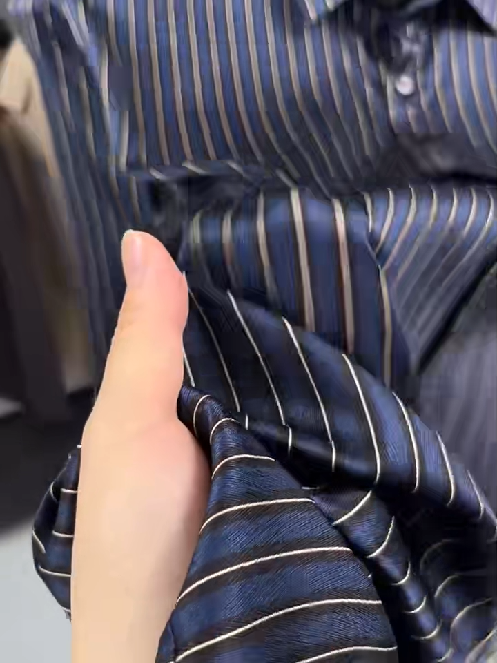 Video showcasing a Men's regular-fit luxury shirt in Burning the Midnight Oil and inky Prose colors, featuring a vertical stripe pattern over a textured herringbone weave, made from a Mulberry silk-spandex blend. — From Borcelleclothes.