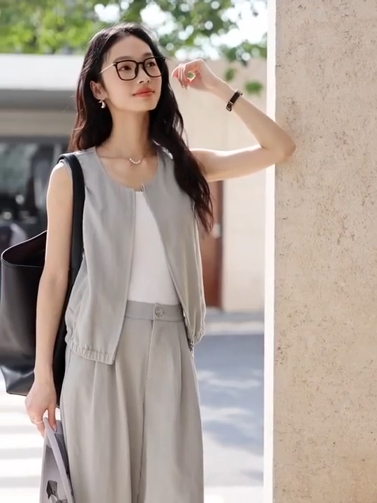 Video showcasing a Women's French Grey two-piece set featuring a sleeveless zip-front jacket and softly structured twill trousers — an understated city ensemble in a breathable, denim-inspired fabric. From Borcelleclothes.