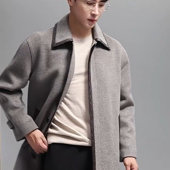 Video showcasing a Men’s wool-cashmere coat with leather cord weaving in Mountain Mist, pointed collar, concealed placket, raglan sleeves, and leather-trimmed pockets. From Borcelleclothes.