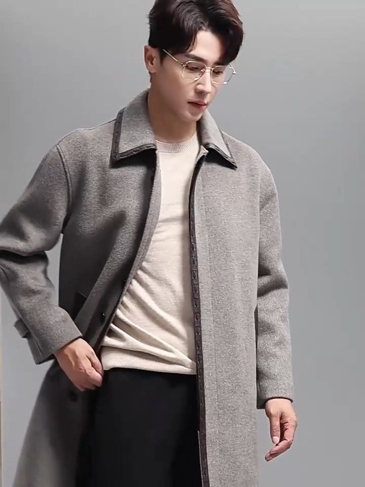 Video showcasing a Men’s wool-cashmere coat with leather cord weaving in Mountain Mist, pointed collar, concealed placket, raglan sleeves, and leather-trimmed pockets. From Borcelleclothes.