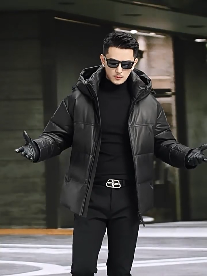 Video showcasing a Men’s goose down jacket in matte cowhide leather with a sculpted stand collar integrated into the hood, vertical side zip pockets, and diagonal embossed leather insets — From Borcelleclothes.
