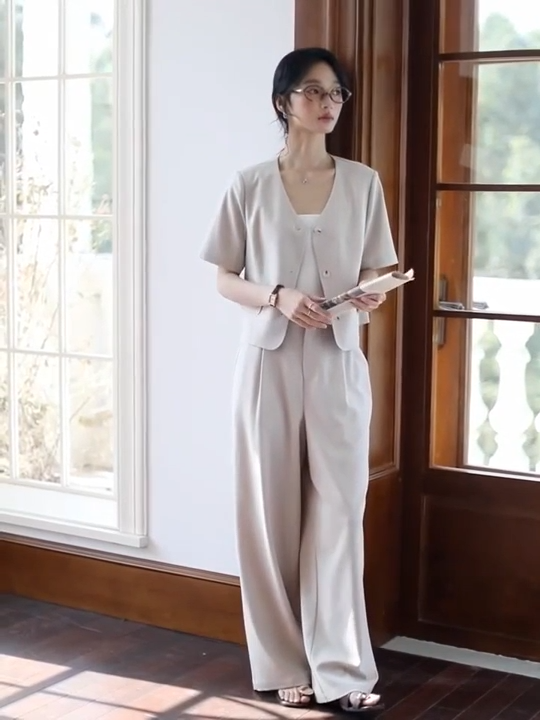 Video showcasing an Alabaster two-piece set with a cropped short-sleeve jacket and fluid straight-leg trousers in a soft, light beige shade. Minimalist silhouette with classic tailoring details. From Borcelleclothes.