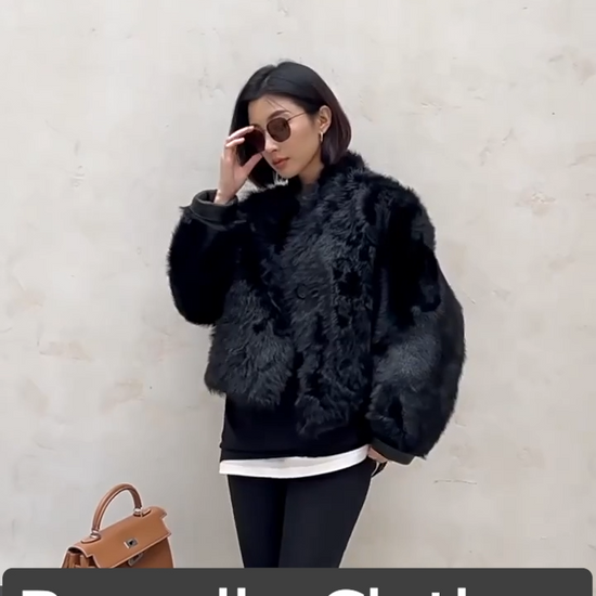 Video showcasing a Women's Reversible cropped shearling jacket in Autographe, featuring a cut-on collar with shoulder darts, softly curled wool, and a dense, inky surface — From Borcelleclothes.