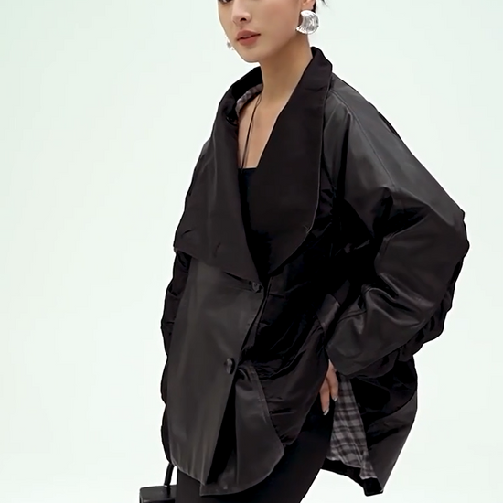 Video showcasing a Women's Architectural cowhide loose-fitting wrap jacket in Beneath the Mask, featuring memory-wire ruched wedges, generous lapels convertible into a high stand collar. — From Borcelleclothes.