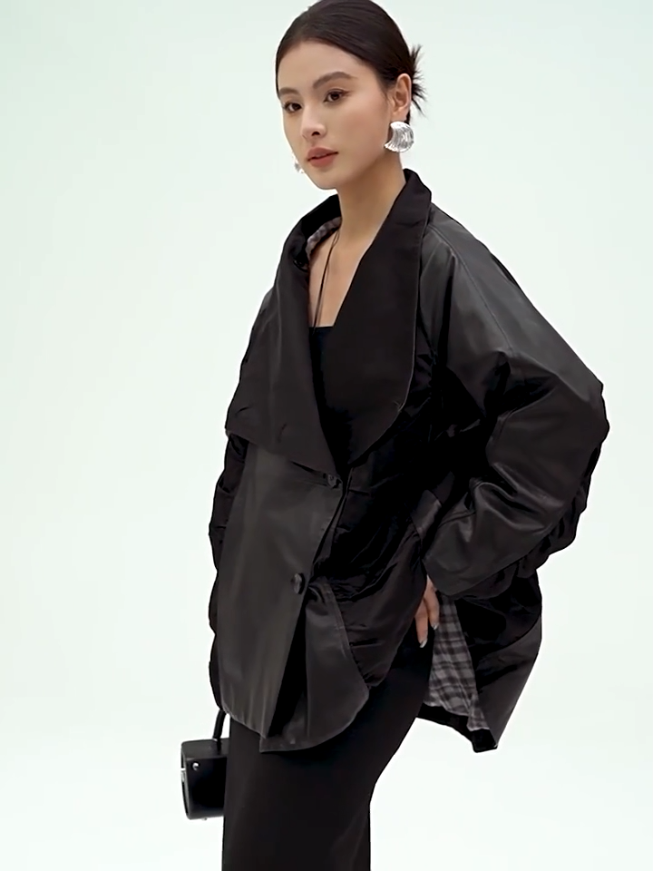 Video showcasing a Women's Architectural cowhide loose-fitting wrap jacket in Beneath the Mask, featuring memory-wire ruched wedges, generous lapels convertible into a high stand collar. — From Borcelleclothes.
