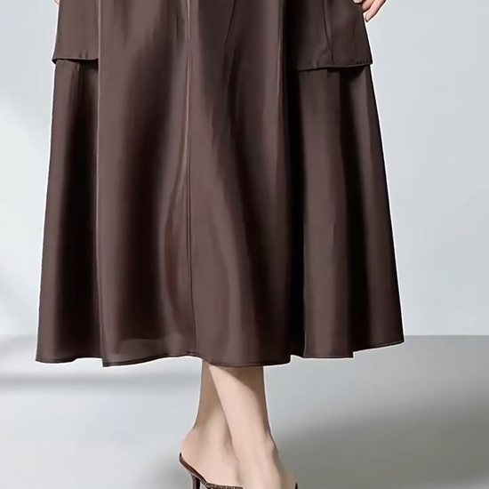 Video showcasing a Women's flared midi cargo skirt crafted from premium Grade 6A Mulberry silk poplin in Bitter Chocolate. Features structured panel seam pockets and an elasticated back. — From Borcelleclothes.