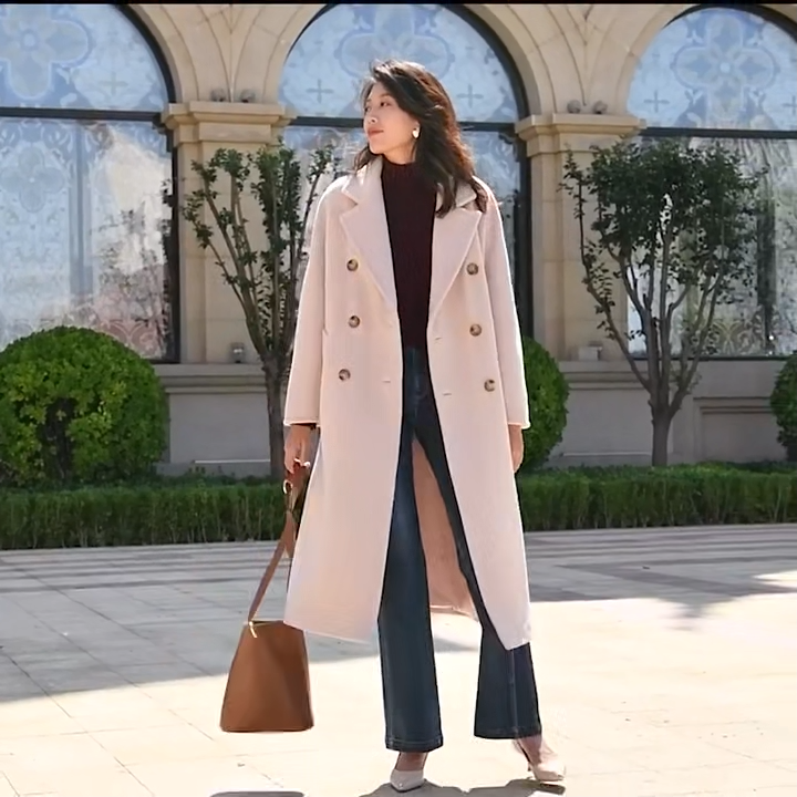 Video showcasing a Women's mid-calf 100% lambswool coat in all colors, featuring a double-breasted design with tortoise-shell buttons and structured sleeve panels. — From Borcelleclothes.