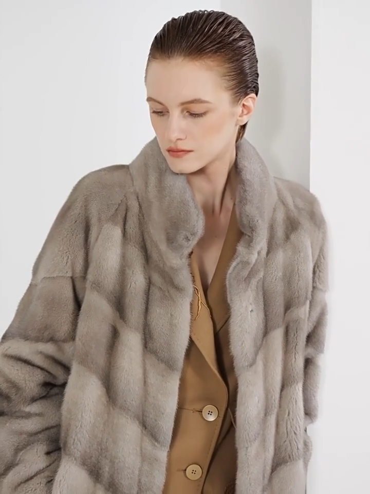 Video showcasing a Women’s mid-calf sheared mink coat with diagonal chevron paneling, stand collar, hidden hooks, and internal drawstring waist — In colors —Calm, Call of the Loon, and Beyond Black. — From Borcelleclothes.