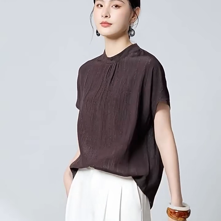 Video showcasing a Women's 19 Momme stretch silk jacquard blouse in Carried by Monsoon and Falling Memories. Features fluted texture, delicate gathers beneath a stand collar, and short kimono sleeves. — From Borcelleclothes.
