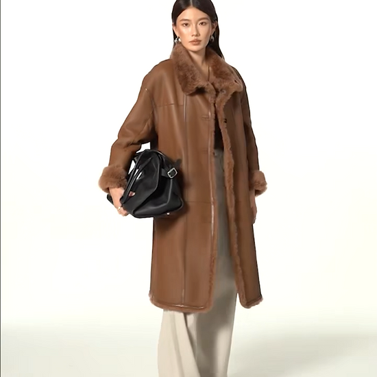 Video showcasing a Women’s reversible shearling coat in Cedar Resin color, featuring glossy leather trims and mid-calf silhouette — From Borcelleclothes.