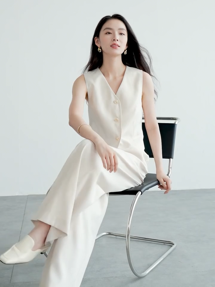 Video showcasing a Women's two-piece linen blend set in C’est Ça color. Mid-waist trousers with crossed pleats, tailored V-neck vest with tone-on-tone buttons. — From Borcelleclothes.