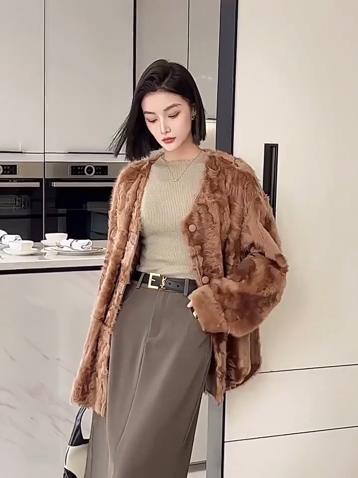 Video showcasing a Women's reversible shearling jacket in Cinnamon Flame, featuring an arched hem, leather-wrapped buttons, and a textured unshorn wool surface — From Borcelleclothes.