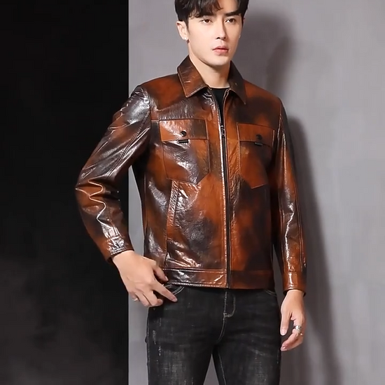 Video showcasing a Men's Mottled cowhide leather jacket with pointed collar, chest flap pockets, snap cuffs, and hem band; quiet warmth before it’s named. From Borcelleclothes.