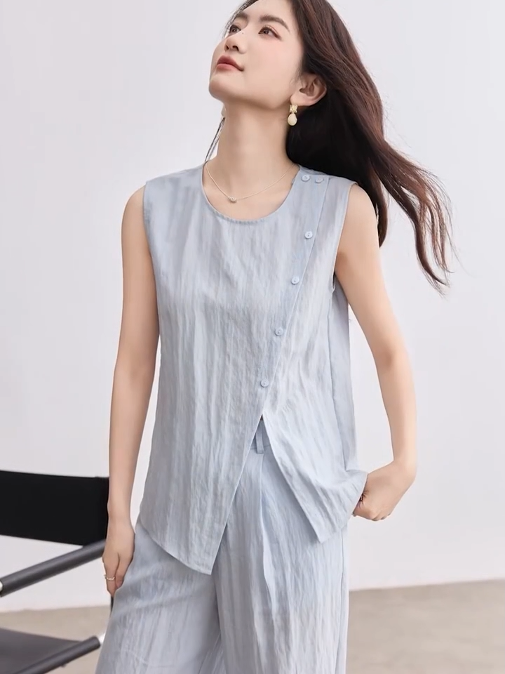 Video showcasing a Women's light blue asymmetrical wrap top and matching wide-leg pleated trousers in a crinkled linen-lyocell blend. — From Borcelleclothes.