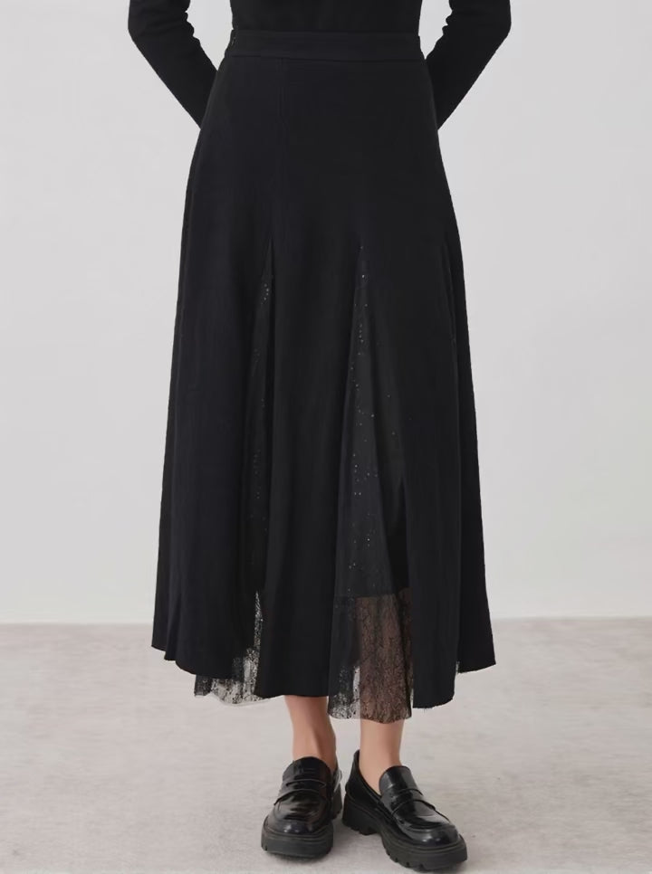 Video showcasing a Women's mid-calf merino wool blend godet skirt in Game in Black. Structural wool panels open into fluid, sheer mesh inserts overlaid with lace. — From Borcelleclothes.