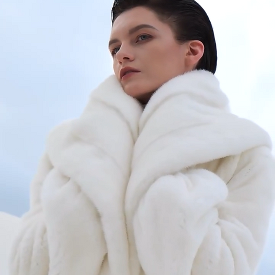 Video showcasing a Women’s wrap mink coat with a generous shawl collar and self-tie belt, in Donne-Moi Ton Cœur color, featuring a flared silhouette and calf length — From Borcelleclothes.