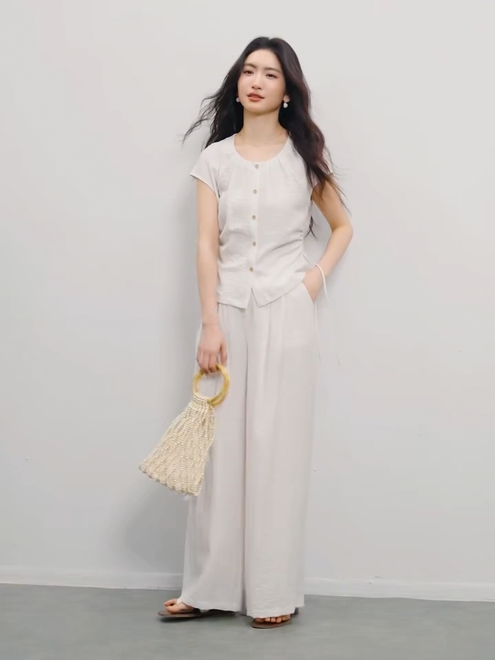 Video showcasing a Women's set in crinkled fabric, showing a sleeveless top with a gathered neck and drawstring waist, and matching wide-leg pants. Shown in Éther de Marbre and Bleu Soleil colors. — From Borcelleclothes.