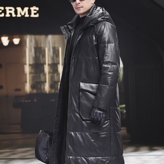 Video showcasing a Men’s mid-calf cowhide down coat in Onyx with sculptural collar-hood, two-way zip, curved cargo pockets, and interior leather-trimmed pockets — From Borcelleclothes.