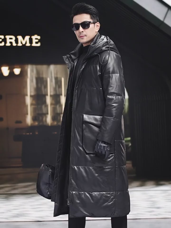Video showcasing a Men’s mid-calf cowhide down coat in Onyx with sculptural collar-hood, two-way zip, curved cargo pockets, and interior leather-trimmed pockets — From Borcelleclothes.