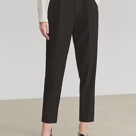 Video showcasing Women's tailored cropped trousers in Sand Brown and Onyx, featuring front pleats, tonal decorative buttons, and a discreet embroidered signature at the waistband. From Borcelleclothes.