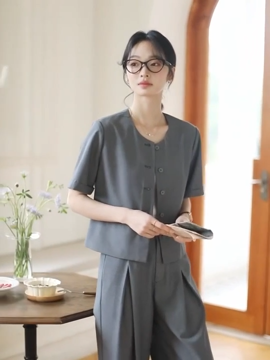 Video showcasing a Women's two-piece set in Fiord grey-blue — features a short five-button jacket and wide-leg trousers with crossed front pleats, crafted in fluid, softly textured fabric. From Borcelleclothes.