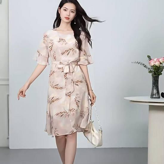 Video showcasing a Women's 100% Mulberry silk dress in First Light color with asymmetrical flounce details and fluttering sleeves. — From Borcelleclothes.