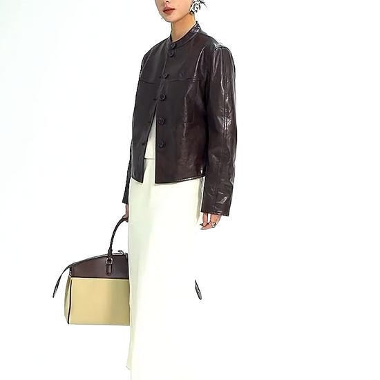 Video showcasing a Women's Full-grain oil-waxed goatskin overshirt jacket in First Impression. Architectural band collar, twin-needle detailing, and dynamic espresso pull-up undertones. — From Borcelleclothes.