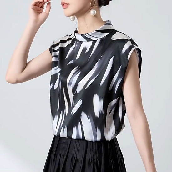 Video showcasing a Women's 19 Momme Mulberry silk satin blouse in Fleeting Impulse. Features an asymmetric rounded fold-over collar and a shoulder placket fastening with crystal buttons. — From Borcelleclothes.