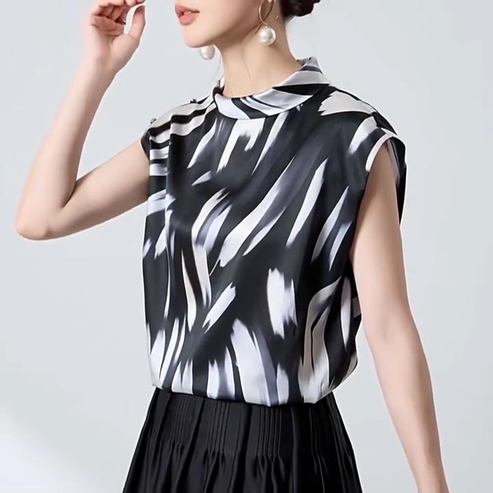 Video showcasing a Women's 19 Momme Mulberry silk satin blouse in Fleeting Impulse. Features an asymmetric rounded fold-over collar and a shoulder placket fastening with crystal buttons. — From Borcelleclothes.