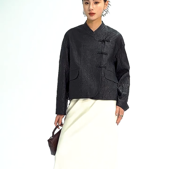 Video showcasing a Women's Cropped wrap jacket in full-grain crinkled sheepskin. An austere silhouette with an asymmetrical satin pankou closure, mandarin collar, and high-low hem.  Color - Frost-Glazed Lava. — From Borcelleclothes.