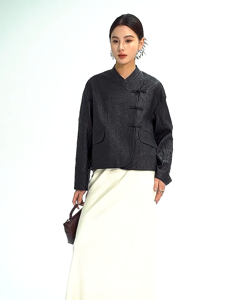 Video showcasing a Women's Cropped wrap jacket in full-grain crinkled sheepskin. An austere silhouette with an asymmetrical satin pankou closure, mandarin collar, and high-low hem.  Color - Frost-Glazed Lava. — From Borcelleclothes.