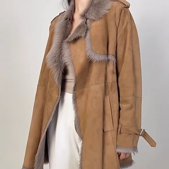 Video showcasing a Women's double-faced goatskin coat in Gold Ransom, with a storm flap, notch lapels, and self-tied belt. — From Borcelleclothes.