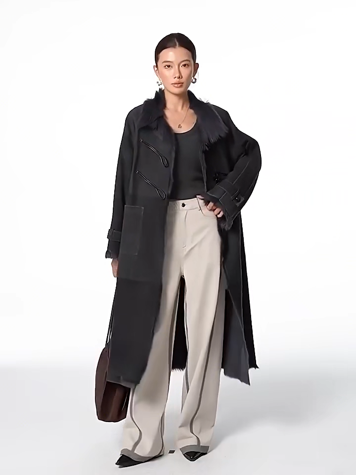 Video showcasing a Women's mid-calf goatskin coat in Inner Depth, with toggle closure on the diagonally arranged leather air loops; Toscana fur visible at uncut edges — From Borcelleclothes.