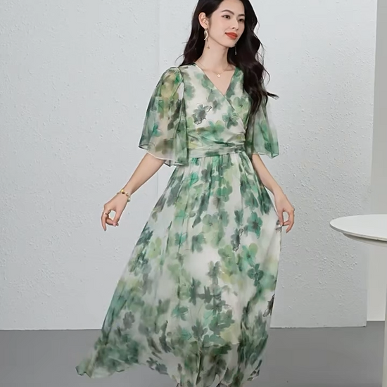 Video showcasing a Translucent Jade Breeze silk georgette midi dress with a wrap bodice, 1/2 flutter sleeves, and watercolor jade floral patterns on a misty background. — From Borcelleclothes.