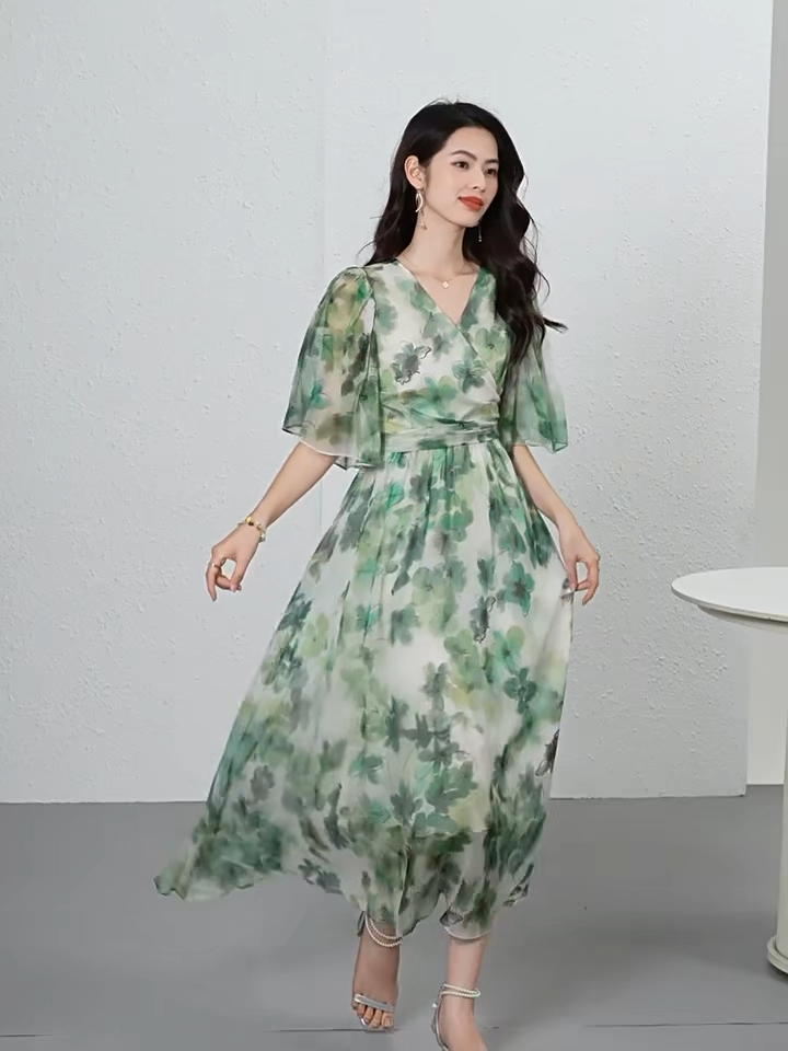 Video showcasing a Translucent Jade Breeze silk georgette midi dress with a wrap bodice, 1/2 flutter sleeves, and watercolor jade floral patterns on a misty background. — From Borcelleclothes.