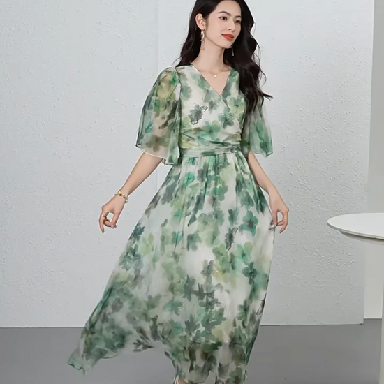 Video showcasing a Translucent Jade Breeze silk georgette midi dress with a wrap bodice, 1/2 flutter sleeves, and watercolor jade floral patterns on a misty background. — From Borcelleclothes.